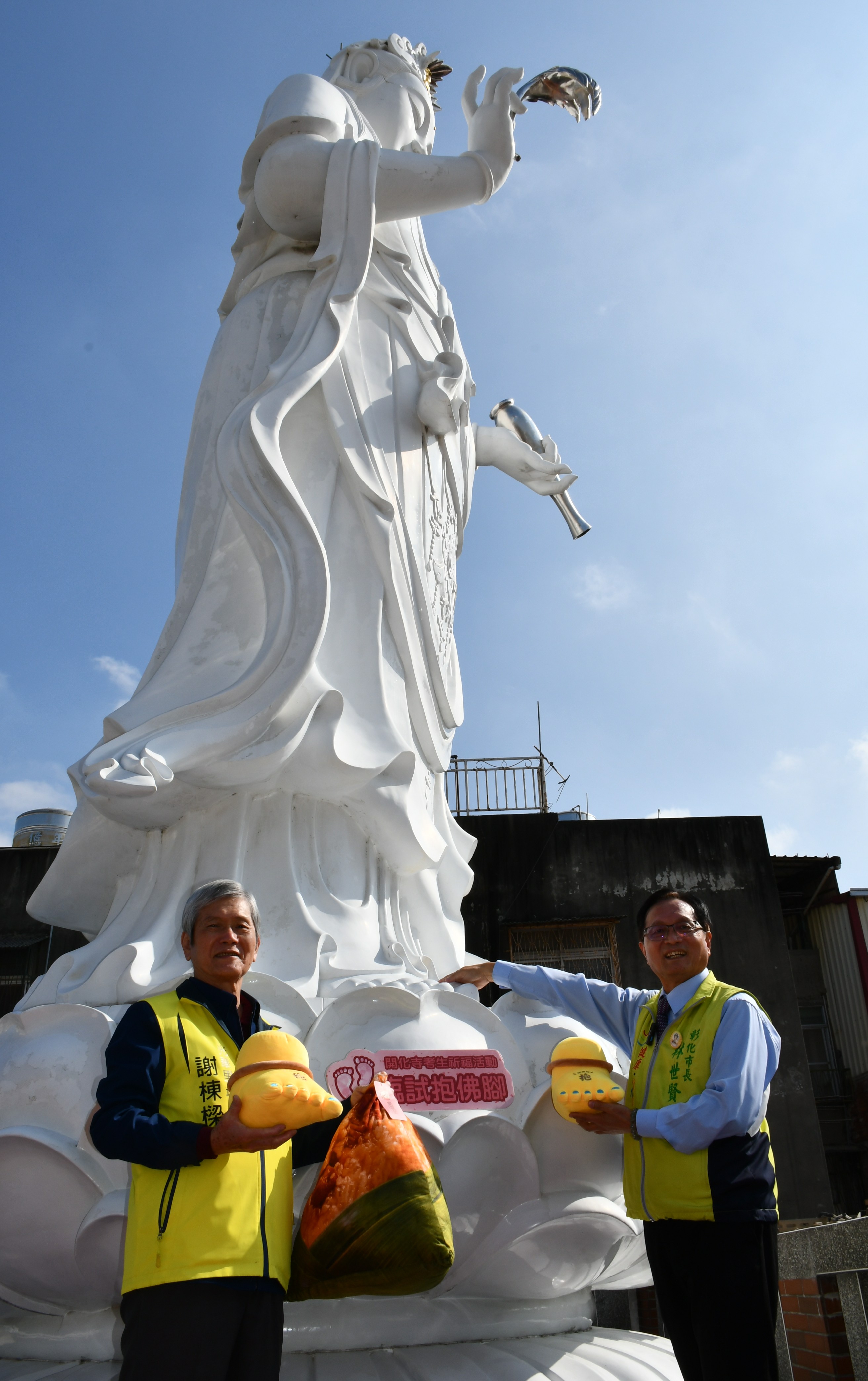 林世賢市長在開化寺樓頂的8公尺高大觀音聖像旁示範如何「抱佛腳」祈求觀音媽加持.jpg