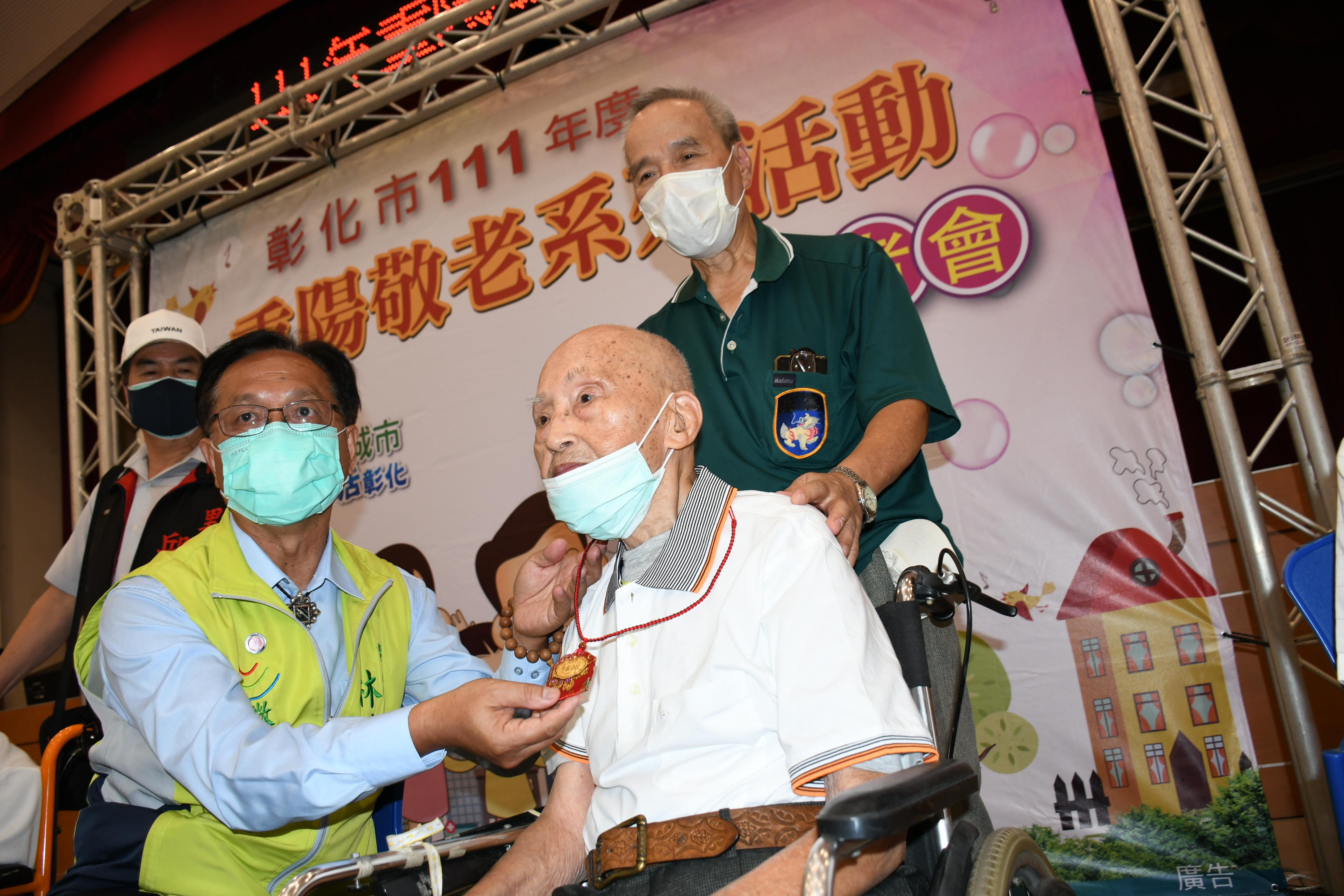 林世賢市長為已經102歲高齡的王欽章老先生戴上了金鑜片